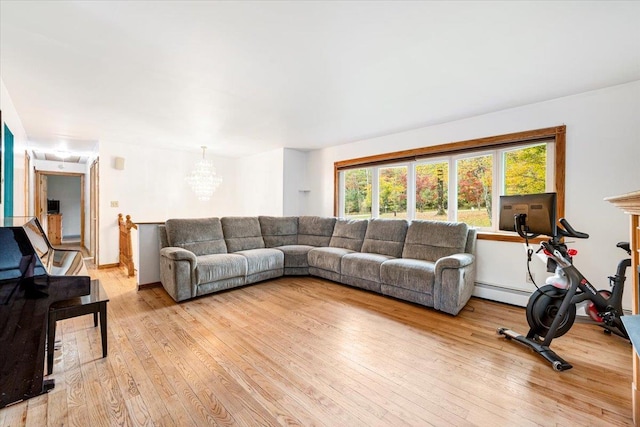 living room with a notable chandelier, light hardwood / wood-style flooring, and baseboard heating