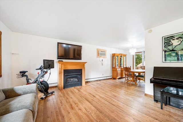 living room with baseboard heating, wood-type flooring, an inviting chandelier, and an AC wall unit