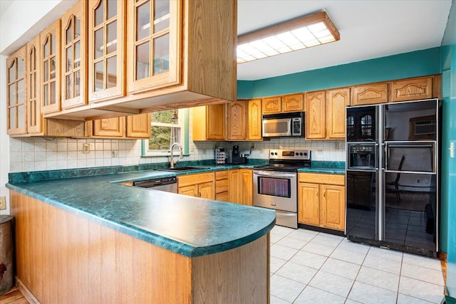 kitchen with tasteful backsplash, appliances with stainless steel finishes, sink, and kitchen peninsula