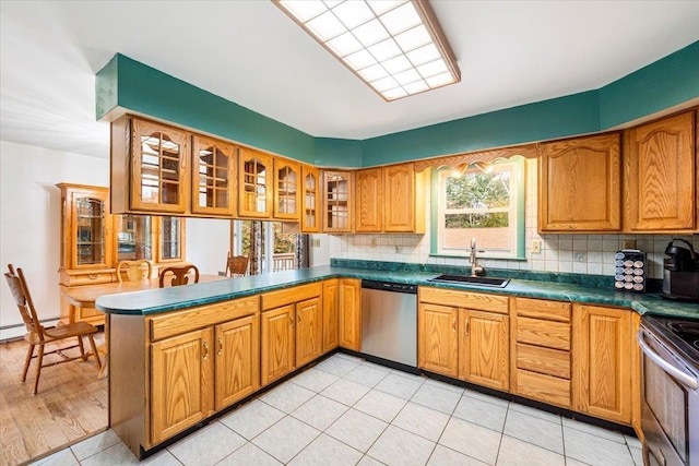 kitchen featuring sink, backsplash, light tile patterned floors, kitchen peninsula, and stainless steel appliances