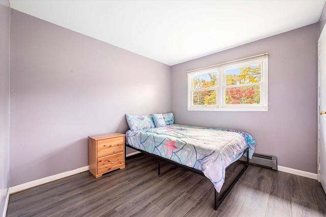 bedroom featuring dark hardwood / wood-style flooring and a baseboard heating unit