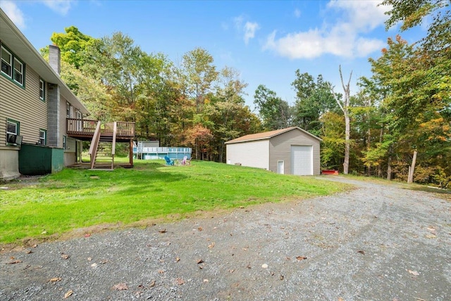 view of yard with an outbuilding, a garage, and a swimming pool side deck