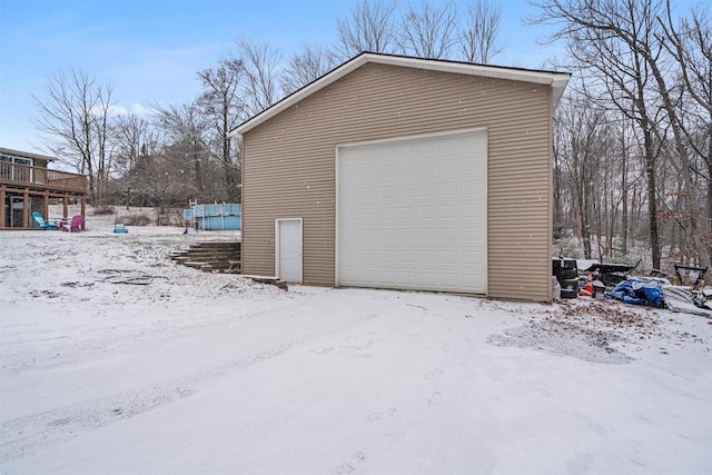 snow covered garage featuring a swimming pool