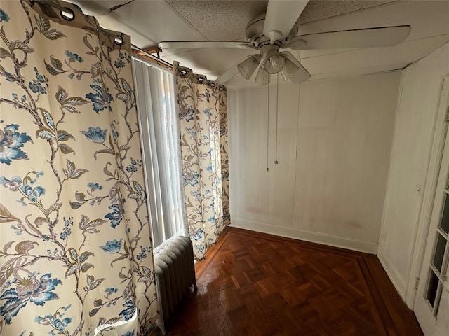 hallway with radiator heating unit and dark parquet floors