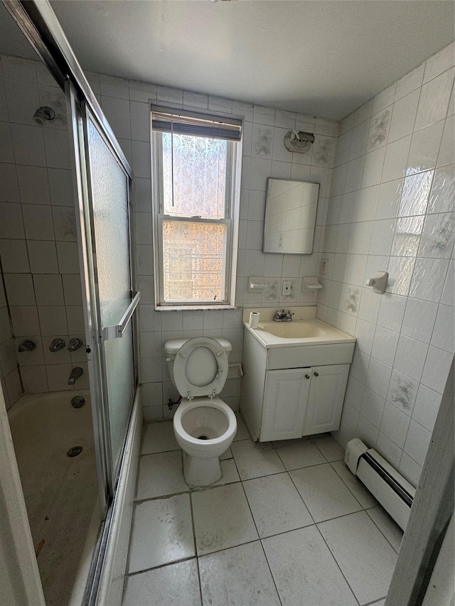 full bathroom with combined bath / shower with glass door, baseboard heating, tile walls, vanity, and toilet