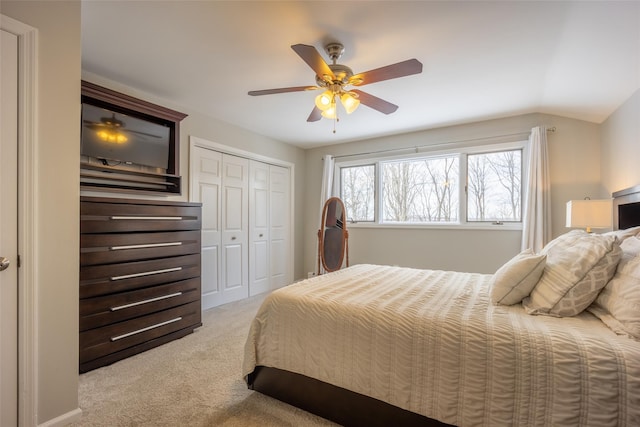 bedroom featuring light carpet, ceiling fan, a closet, and lofted ceiling