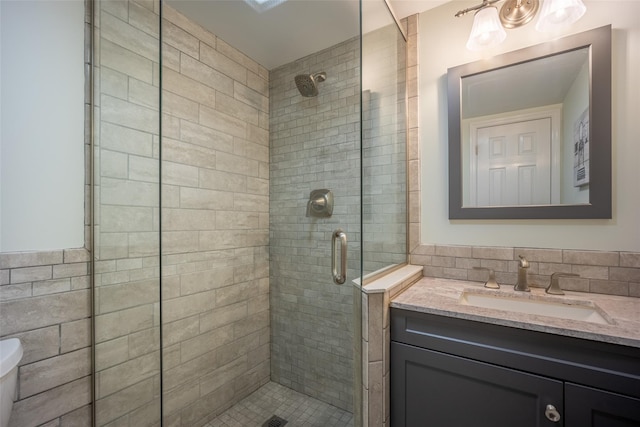 bathroom with a shower stall, vanity, and toilet