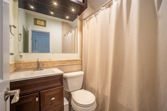 bathroom featuring tile walls, toilet, and vanity