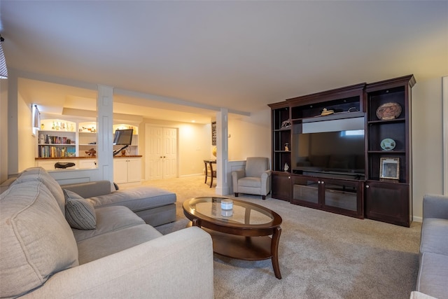 living area featuring baseboards and light carpet