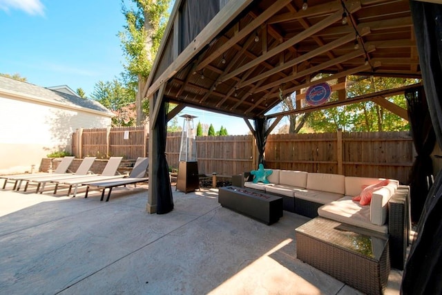 view of patio / terrace with a gazebo, an outdoor living space with a fire pit, and fence