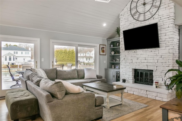 living room featuring hardwood / wood-style floors, a fireplace, built in shelves, vaulted ceiling, and wooden ceiling