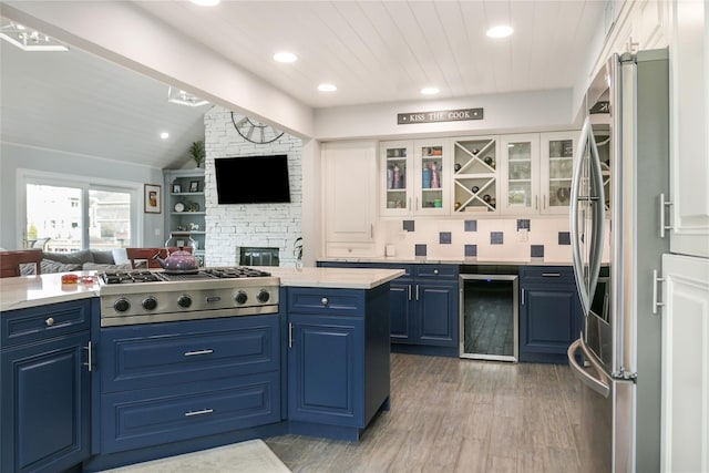 kitchen featuring white cabinets, appliances with stainless steel finishes, blue cabinetry, and wine cooler