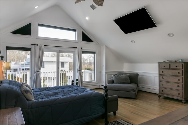 bedroom featuring multiple windows, vaulted ceiling, hardwood / wood-style floors, and access to outside