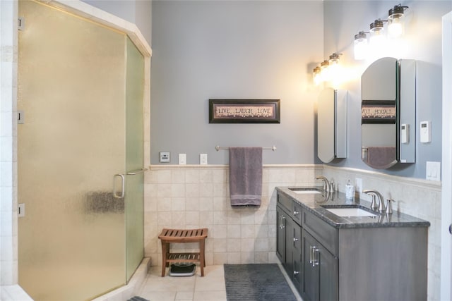 bathroom featuring vanity, a shower with shower door, tile patterned flooring, and tile walls