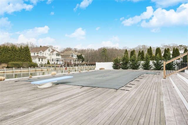 view of pool with a diving board and a water view