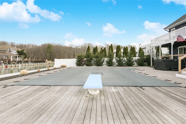 view of swimming pool with a deck with water view and a hot tub