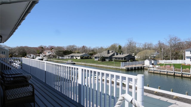 wooden terrace featuring a residential view and a water view