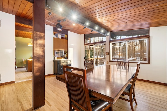 dining area with rail lighting, wood ceiling, beam ceiling, and light hardwood / wood-style floors