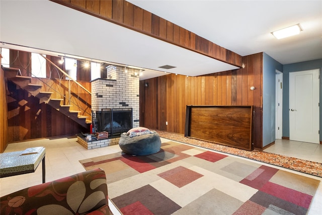 living room with a fireplace and wood walls