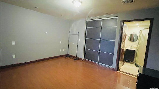 unfurnished bedroom featuring a closet and ensuite bathroom