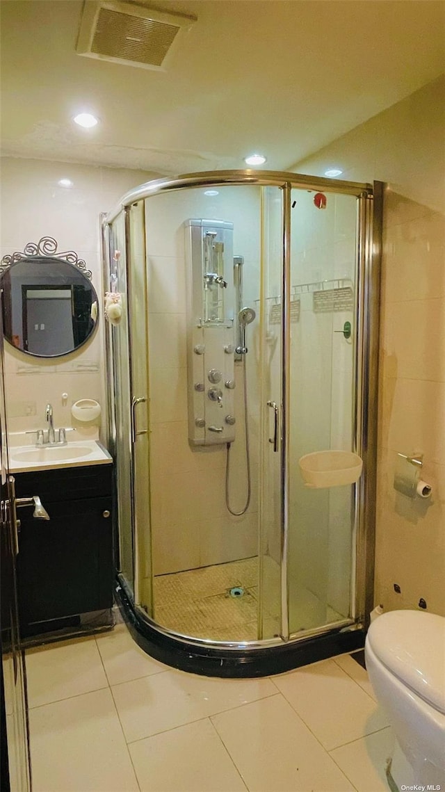 bathroom with an enclosed shower, vanity, tile patterned floors, and toilet