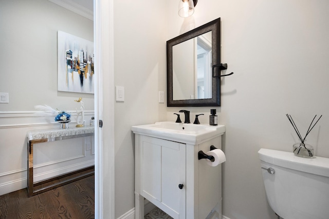 bathroom with vanity, wood-type flooring, ornamental molding, and toilet