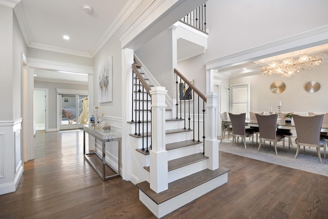 stairway featuring ornamental molding, wood-type flooring, and an inviting chandelier