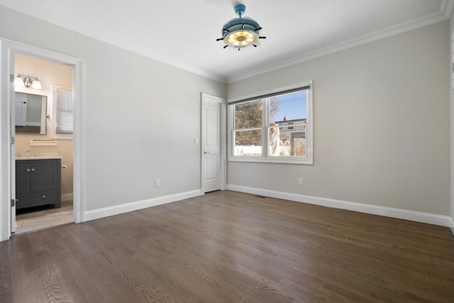 unfurnished bedroom with ornamental molding, sink, dark hardwood / wood-style flooring, and ensuite bath