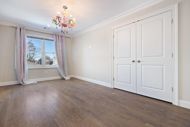 unfurnished bedroom with crown molding, dark hardwood / wood-style flooring, an inviting chandelier, and a closet