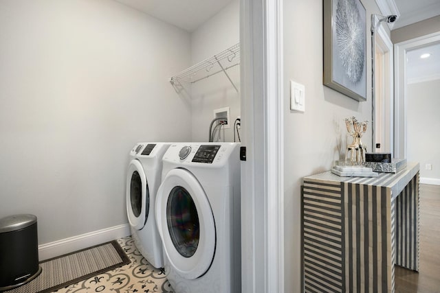 laundry area with crown molding, dark wood-type flooring, and washer and clothes dryer