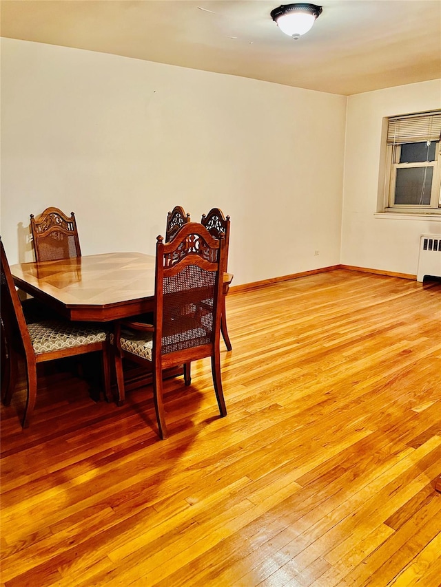 dining area featuring light wood-type flooring and radiator