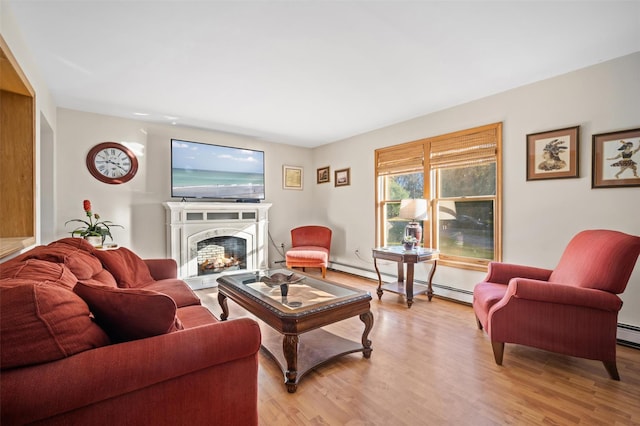 living room with a baseboard heating unit and light wood-type flooring