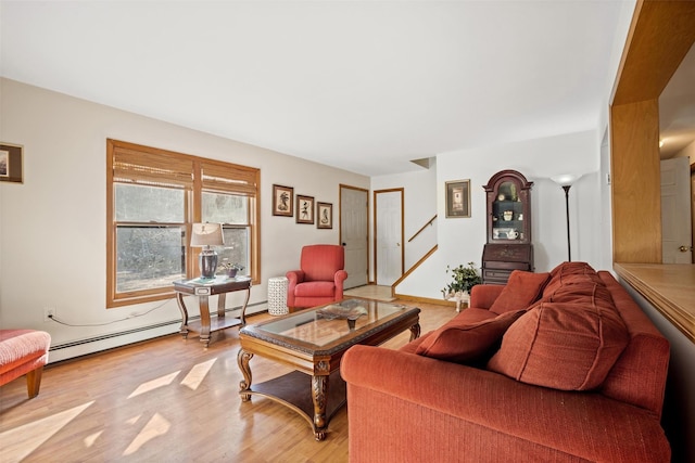 living room featuring a baseboard heating unit and light hardwood / wood-style flooring