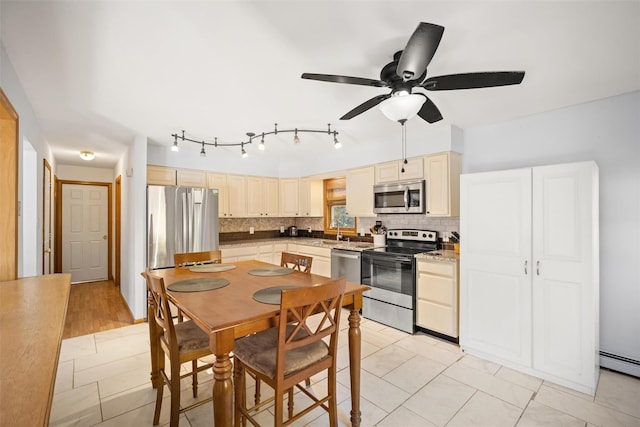 kitchen featuring sink, decorative backsplash, ceiling fan, and appliances with stainless steel finishes