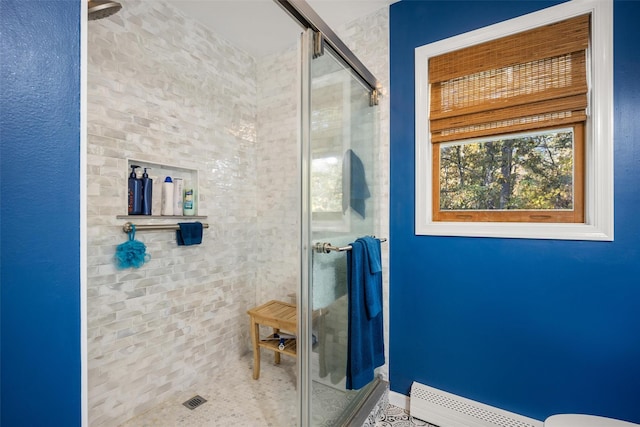 bathroom featuring a baseboard heating unit and a shower with shower door