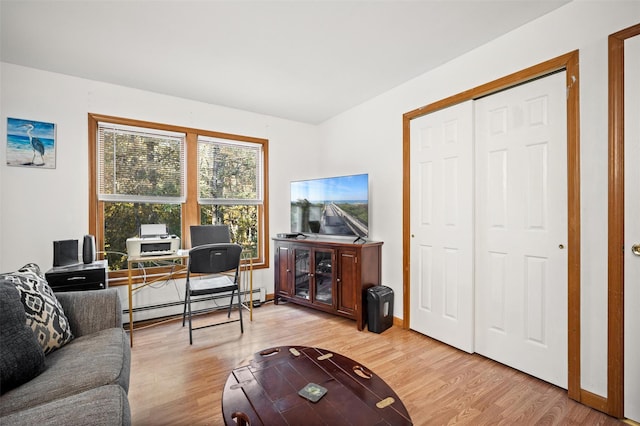 living room featuring light hardwood / wood-style flooring and a baseboard heating unit