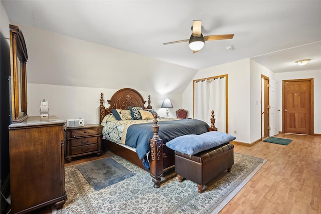 bedroom with ceiling fan, lofted ceiling, and light hardwood / wood-style floors