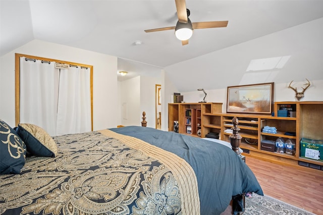 bedroom with hardwood / wood-style flooring, ceiling fan, and vaulted ceiling