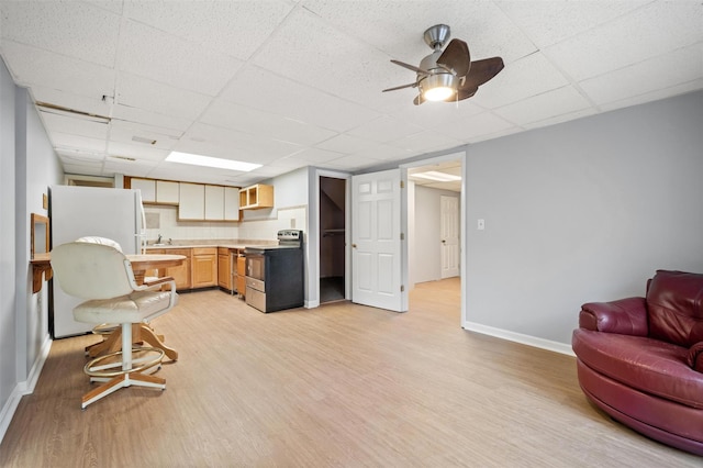 kitchen featuring stainless steel electric stove, white fridge, a drop ceiling, and light hardwood / wood-style floors