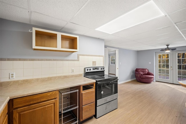 kitchen featuring french doors, a paneled ceiling, light wood-type flooring, and stainless steel electric range