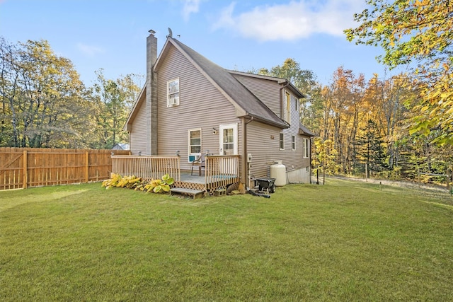 rear view of property with a wooden deck and a lawn