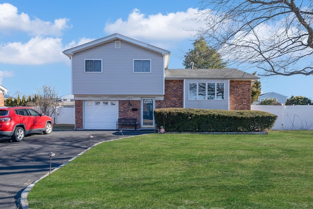 split level home featuring a garage and a front lawn