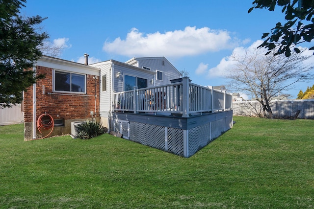 rear view of property featuring a yard and a deck