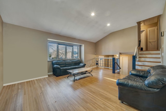 living room featuring lofted ceiling and light hardwood / wood-style floors