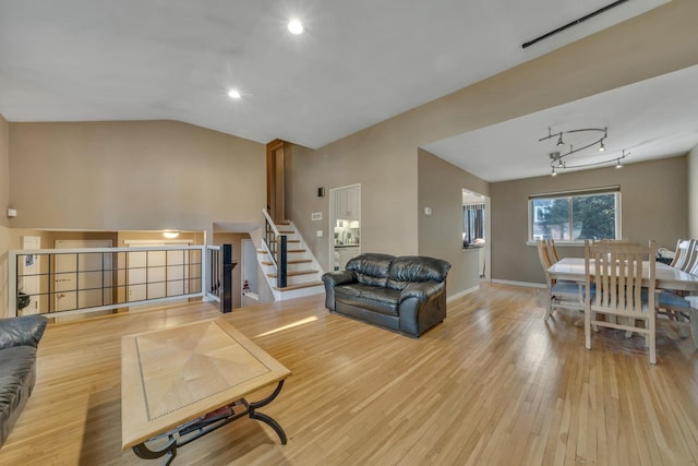 living room with light hardwood / wood-style flooring and vaulted ceiling