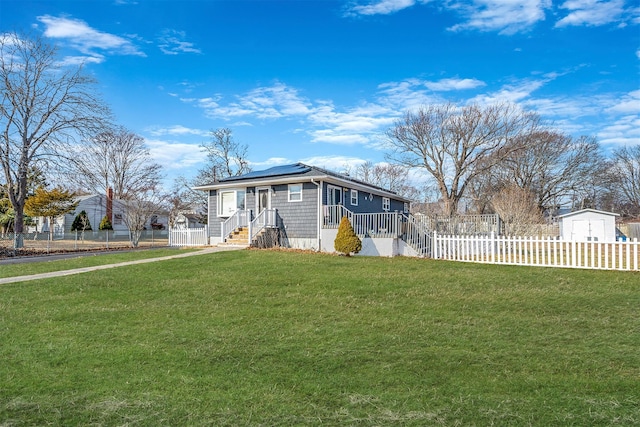 view of front of home with a front yard and solar panels