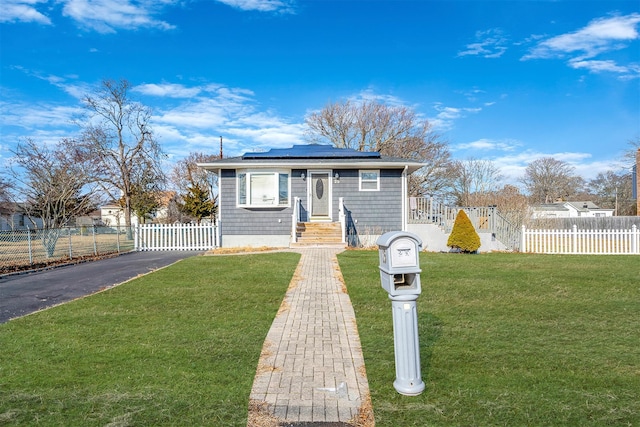 bungalow-style home with a front yard and solar panels