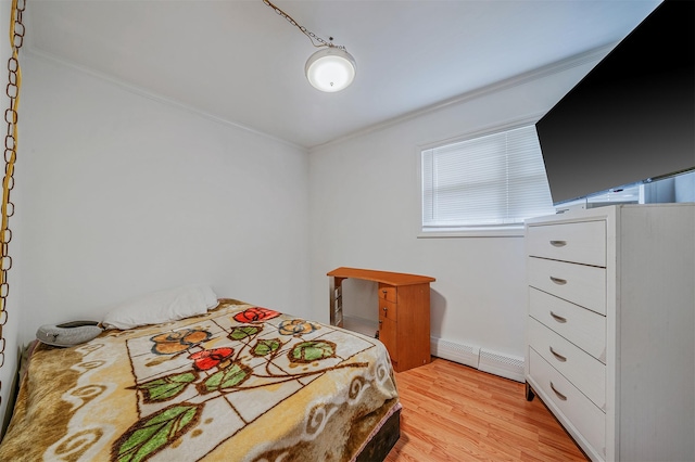 bedroom featuring a baseboard radiator, ornamental molding, and light hardwood / wood-style floors