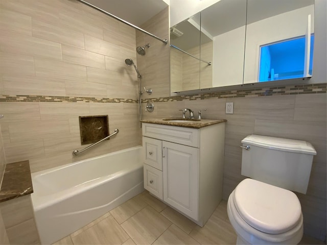 full bathroom featuring tiled shower / bath combo, vanity, tile walls, and toilet