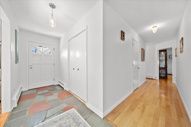 entrance foyer featuring a baseboard heating unit and wood-type flooring